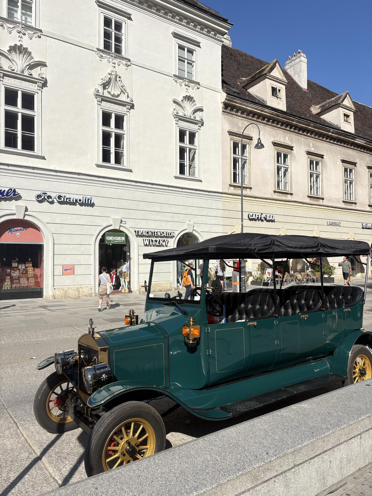 Dark green vintage electric vehicle on Vienna’s Graben in daytime