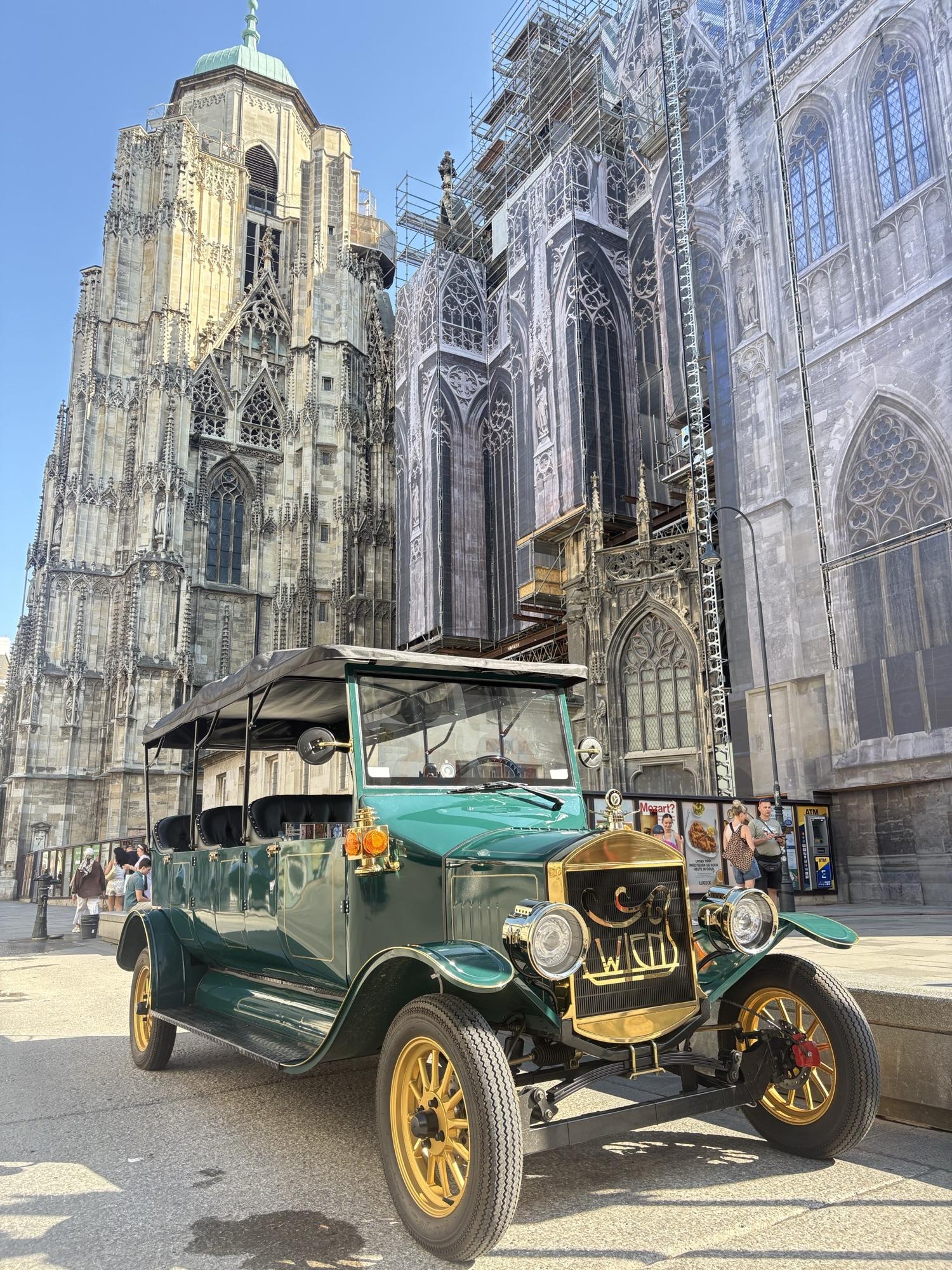 Dark green vintage EV near St. Stephen’s Cathedral in daytime
