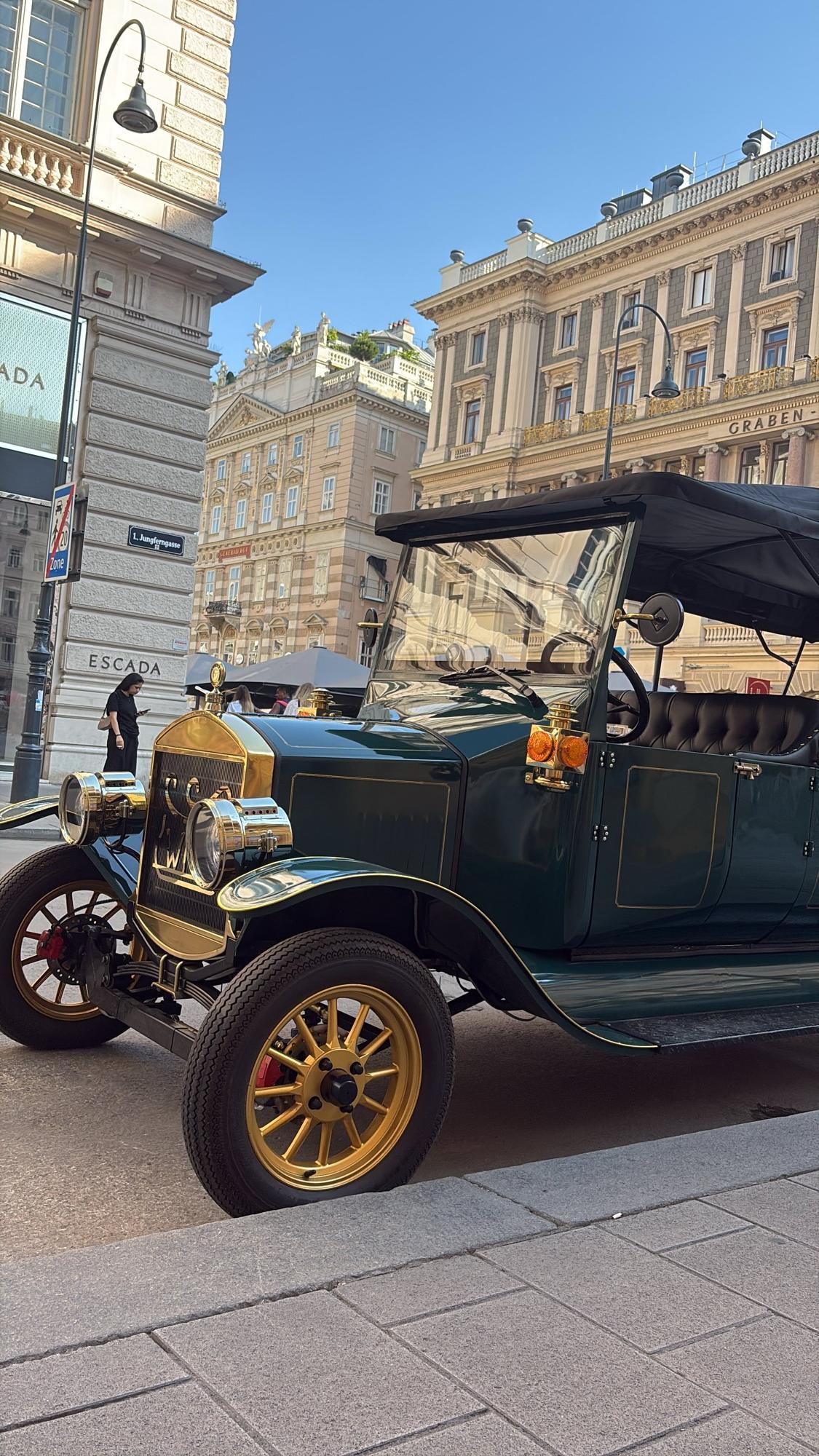 Dark green vintage electric tour vehicle on Vienna’s Graben